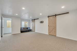 Interior space featuring a barn door and carpet floors