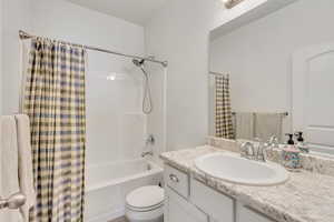 Full bathroom featuring vanity, toilet, and shower / tub combo