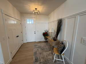 Foyer entrance featuring light hardwood / wood-style flooring and an inviting chandelier