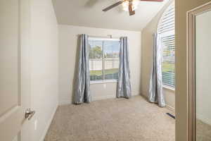 Unfurnished room with vaulted ceiling, light colored carpet, and ceiling fan