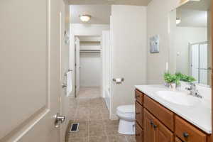 Bathroom featuring vanity, toilet, and tile patterned flooring