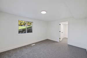 Unfurnished room with dark colored carpet