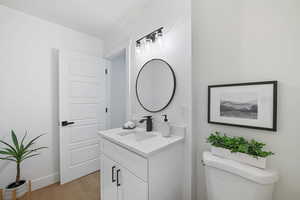 Bathroom with vanity, toilet, and hardwood / wood-style flooring