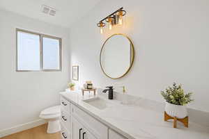 Bathroom with vanity, hardwood / wood-style flooring, and toilet