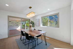 Dining space featuring a notable chandelier, a healthy amount of sunlight, and light wood-type flooring