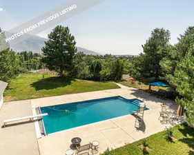 View of pool with a lawn, a diving board, a patio, and a mountain view