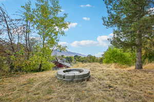 View of yard featuring an outdoor fire pit and a mountain view