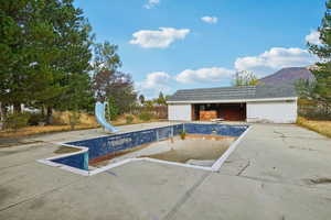 View of pool featuring a mountain view and an outbuilding