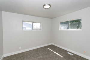 Unfurnished room with carpet and a textured ceiling