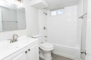 Full bathroom featuring vanity, toilet, wood-type flooring, and tiled shower / bath