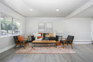 Living room with beam ceiling and wood-type flooring