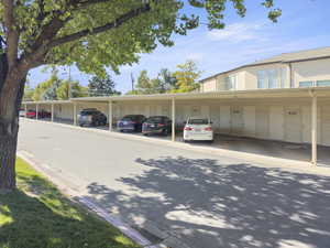 View of parking / parking lot featuring a carport