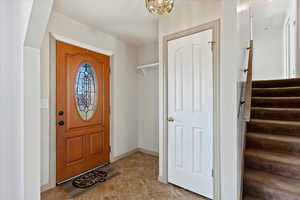 Tiled entrance foyer featuring a notable chandelier