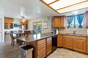 Kitchen featuring dishwasher, decorative backsplash, kitchen peninsula, and a textured ceiling