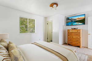 Virtually staged primary bedroom with a textured ceiling