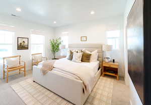 Bedroom featuring light carpet and multiple windows