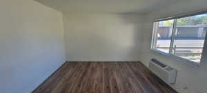 Living room featuring a wall mounted air conditioner, dark hardwood / wood-style floors, and a textured ceiling