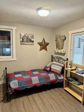 Bedroom with a textured ceiling and hardwood / wood-style flooring