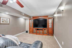 Carpeted living room featuring ceiling fan