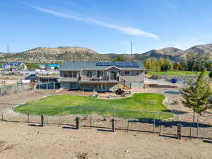 Back of house featuring a patio area, a mountain view, and solar panels