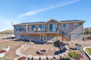 Back of house featuring french doors, a fire pit, and a wooden deck