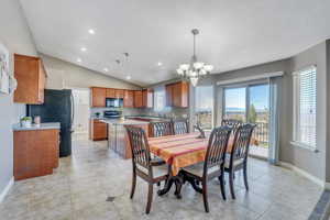 Dining room with vaulted ceiling, a healthy amount of sunlight, and light tile patterned floors