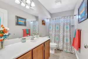 Bathroom featuring vanity, toilet, walk in shower, and tile patterned flooring