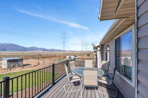 Deck with a mountain view and a lawn