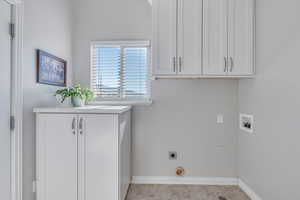 Washroom featuring light tile patterned floors, electric dryer hookup, washer hookup, and cabinets