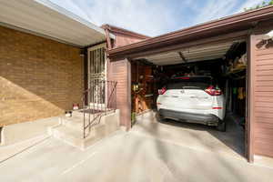 View of garage with door open. A good sized vehicle can be parked inside.