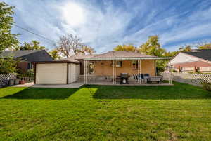 Rear view of house featuring a yard and a patio.