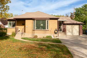 View of front of property featuring a front yard and a garage