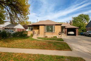 View of front of house featuring a front yard with garage door open. 5+ cars can park on the large driveway strip.