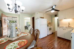 Oversized kitchen dining area with engineered/laminate flooring. chandelier