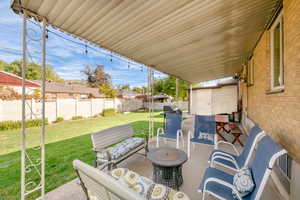 Large back covered patio with view of the backyard.