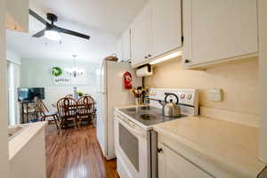 Kitchen with white appliances & white cabinetry.