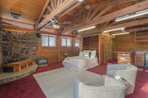 Bedroom with ceiling fan, wooden walls, lofted ceiling with beams, and wooden ceiling featuring a pull down Murphy bed