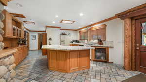 Kitchen with crown molding, a center island, tile counters, and slate flooring