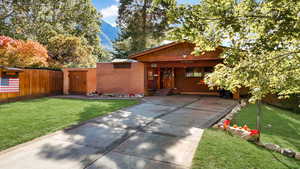 View of front of property with a mountain view and a front yard