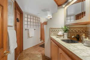 Bathroom featuring tasteful backsplash and vanity