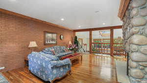 Living room with brick wall, hardwood floors, and a skylight