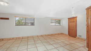 Bedroom featuring light tile patterned floors, wealth of natural light and walk in closet