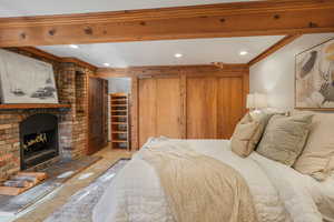 Bedroom with a walk in closet, crown molding, and a fireplace