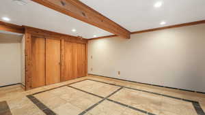 Bedroom space featuring crown molding and beamed ceiling