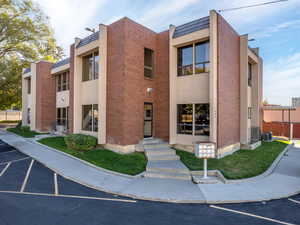 View of building exterior featuring central AC unit