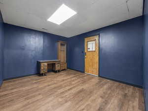 Spare room featuring a paneled ceiling and wood-type flooring