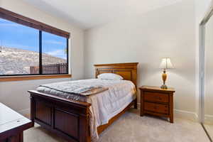 Bedroom with light carpet, a mountain view, and a closet