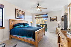 Carpeted bedroom with access to outside and ceiling fan