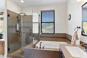 Bathroom featuring vanity, separate shower and tub, and plenty of natural light