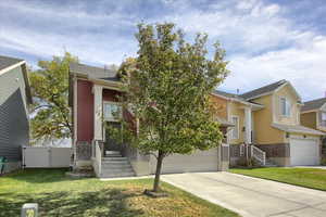 View of front facade featuring a front yard and a garage